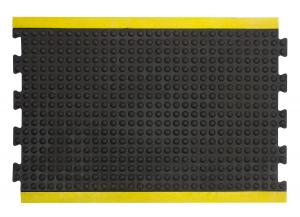 A single middle tile from the modular anti fatigue bubble mat is shown alone. It has a black surface with bubbles and a yellow safety border.