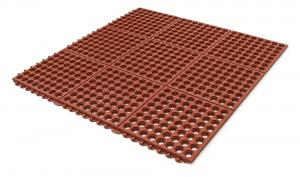 The red comfort link greaseproof anti fatigue mat tiles is shown alone. The holes in its surface allow drainage and its interlocking design allows a cost-effective custom size option.