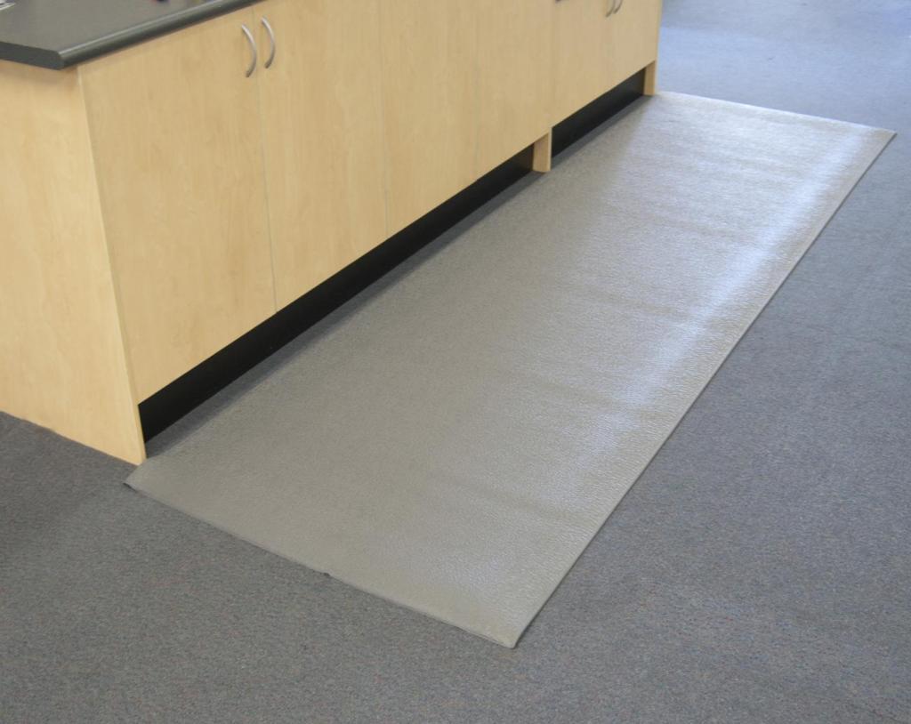 a grey anti static mat is laid on the carpeted floor in front of a wooden cupboard.