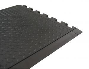 the edge of a welding mat tile shows tabs that interlock with other tiles.