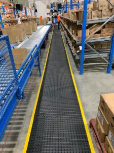 An anti fatigue mat - the Air Grid - is laid at the Revlon factory floor in Canberra. Boxes on shelves can be seen either side of the mat.