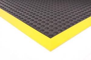 The edge of the Supercomfort anti fatigue mat is shown with a Yellow Safety Border
