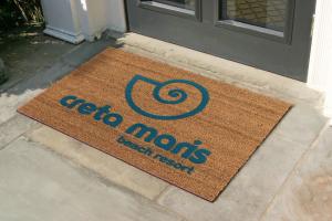 A cour entrance mat is laid outside with the logo and branding 'Creta Maris Beach Resort' . The mat is the Crisp Imprint Coir Mat