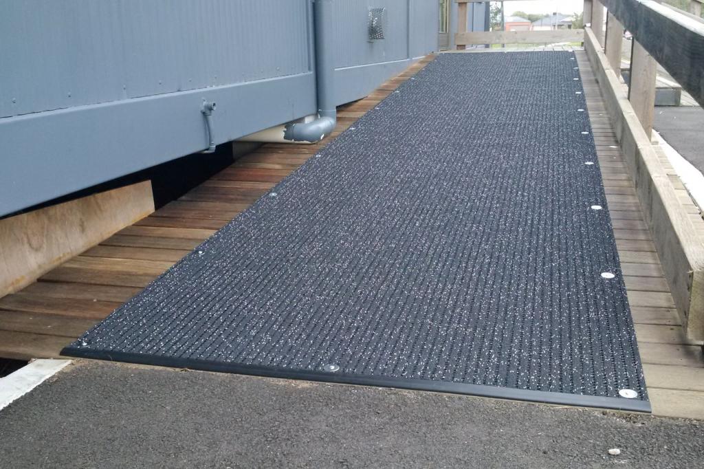 Non Slip Matting - the Ultra Grip - is fitted onto a ramp outside a temporary classroom.