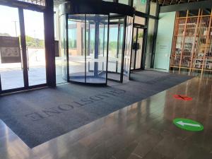 Rotating doors in the entrance to Chadstone Shopping Centre with a smart tough scrape logo mat and paved floor.