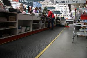 A black non slip, anti fatigue mat - the Super Comfort - is fitted behind a checkout counter at Bunnings.
